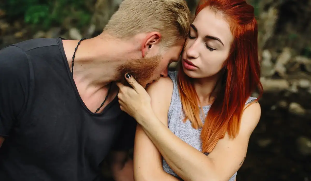 Man kissing redhead's shoulder