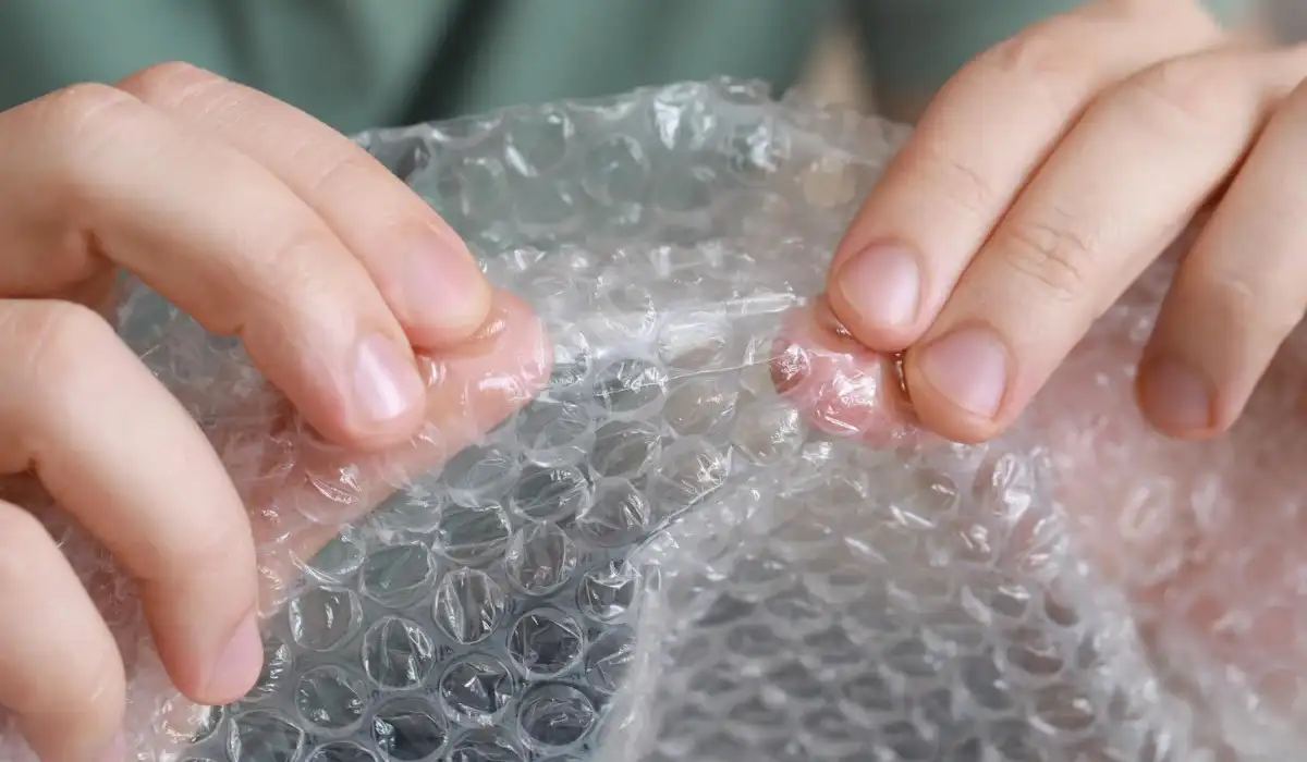 Man popping bubble wrap helping to relieve stress