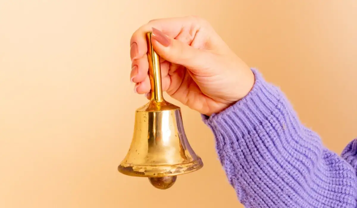 Woman's hand ringing a bell