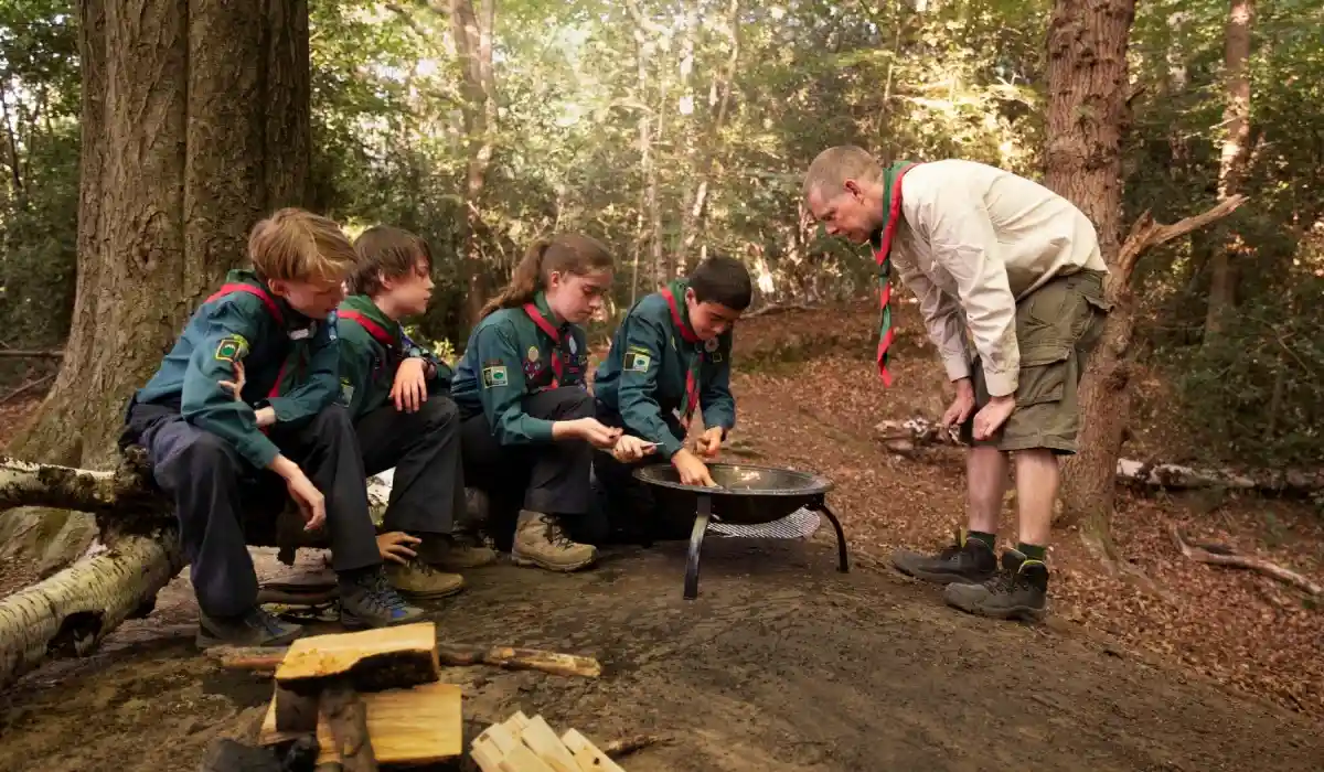 Children having fun as boy scouts, while preparing food in the middle of the forest