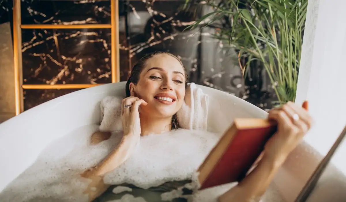 Woman relaxing in a bubble bath while reading