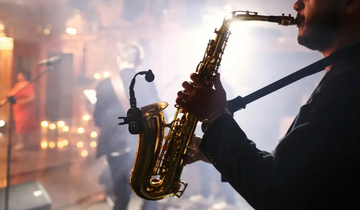 The man plays a saxophone