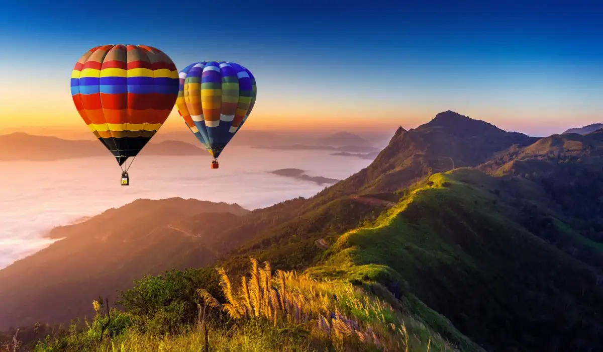 Landscape of morning fog and mountains with hot air balloons at sunrise