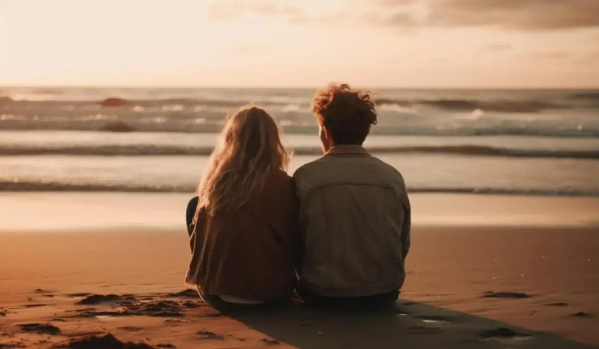 Young couple embracing watching the sunset on the beach