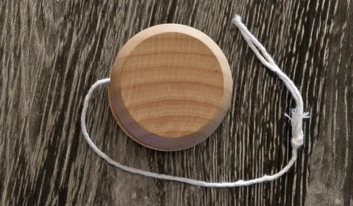 Wooden yoyo on the dark surface of the table.