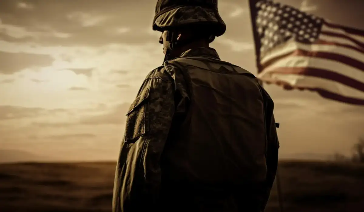 Army soldier standing with American flag aside at sunset