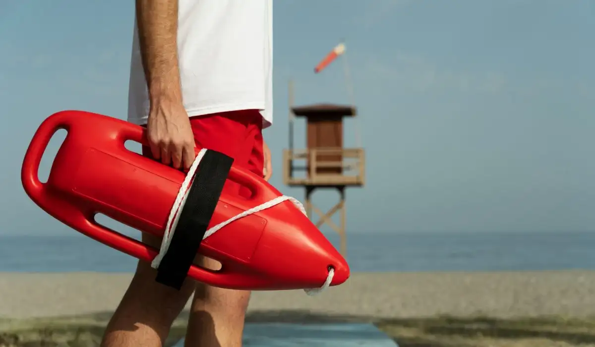 Side view lifeguard holding lifesaving buoy