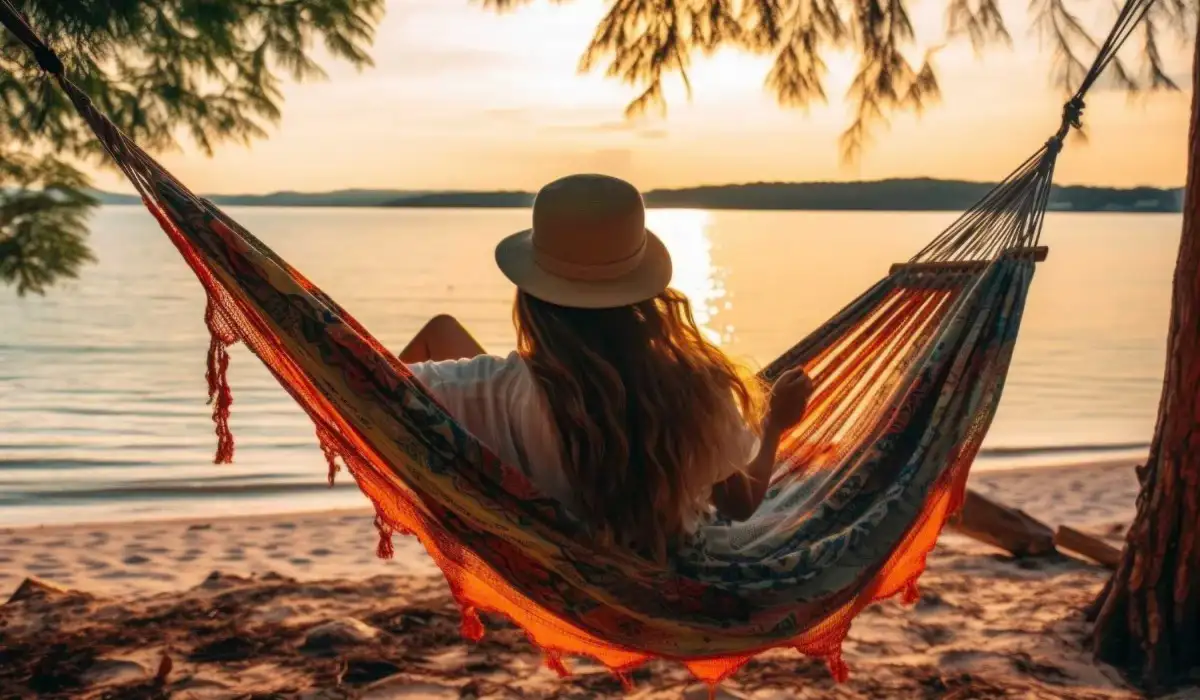 Traveler woman relaxing in a hammock on the summer beach