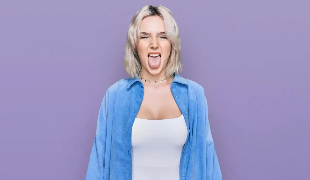 Young blonde woman wearing casual clothes sticking out tongue happy with funny expression