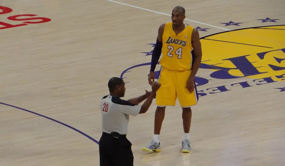 Kobe Bryant standing at midcourt in front of the referee