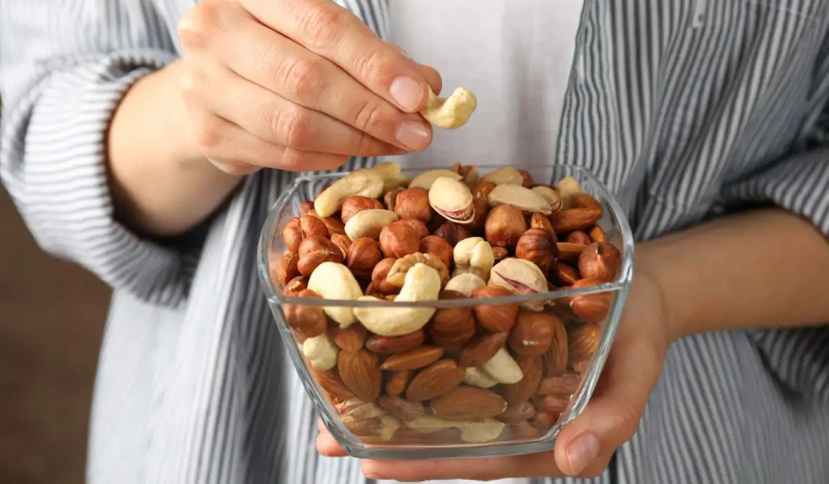 Woman hold bowl with different nuts