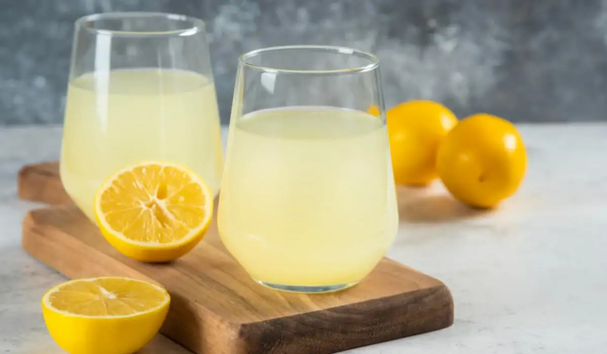 Two cups of tasty lemonade on a wooden board