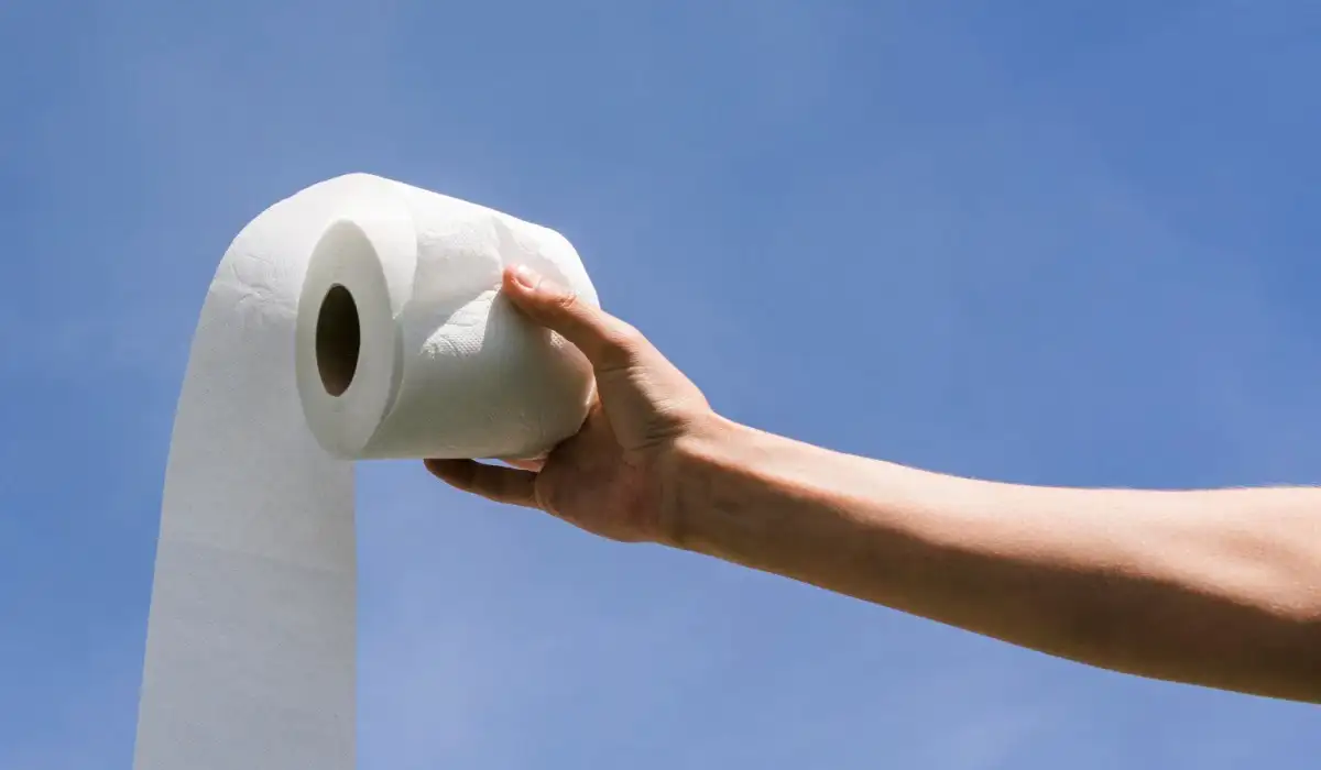 Side view hand with toilet paper roll