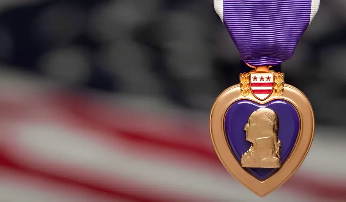Purple heart medal in front of a blurred united states flag