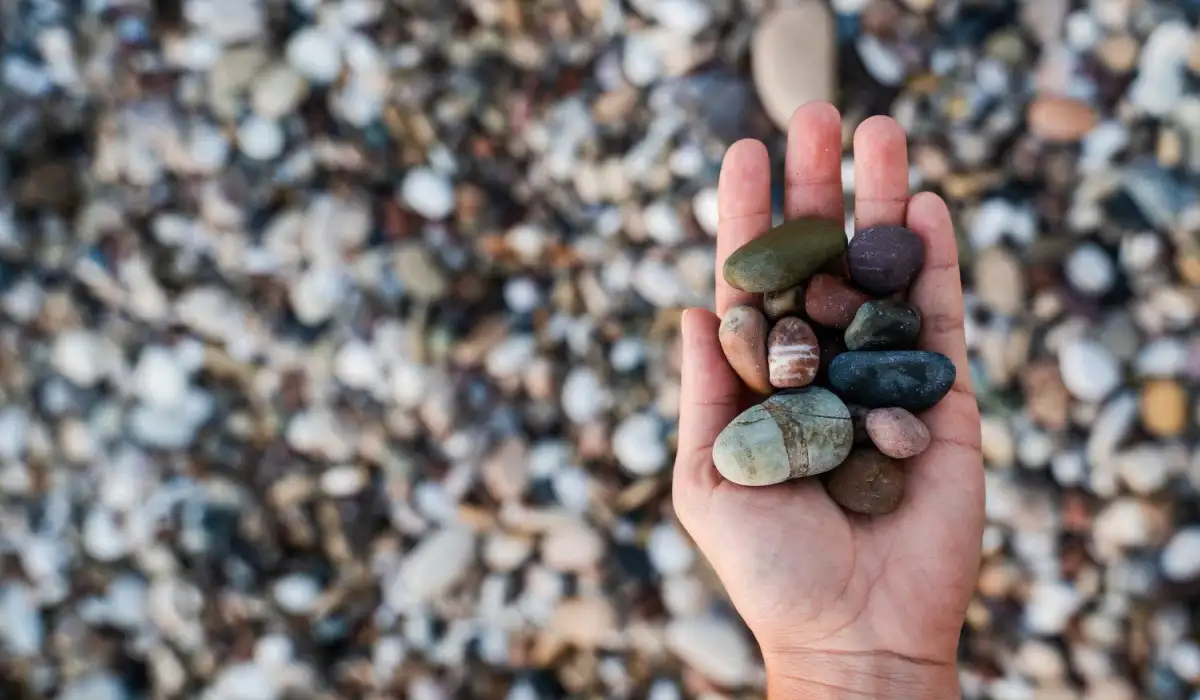 Closeup of female hand with a pile of stones on the beach