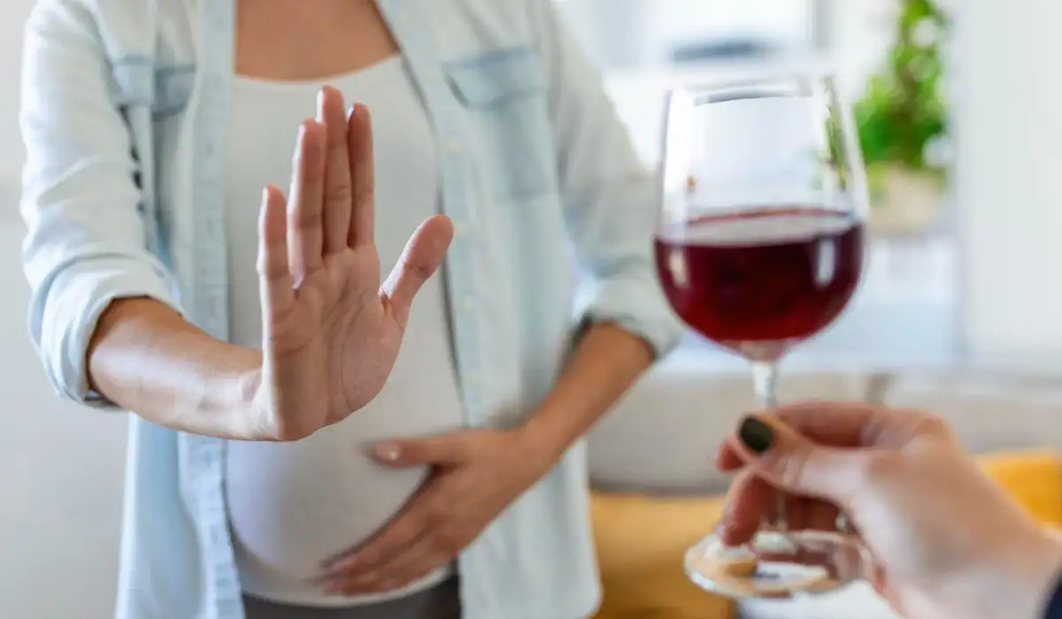 Pregnant woman rejecting a glass of wine