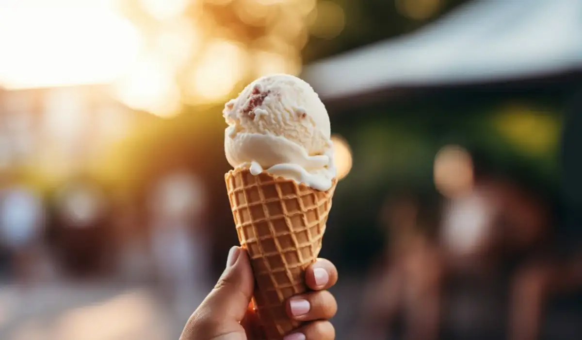 Hand holding a delicious ice cream cone outdoors