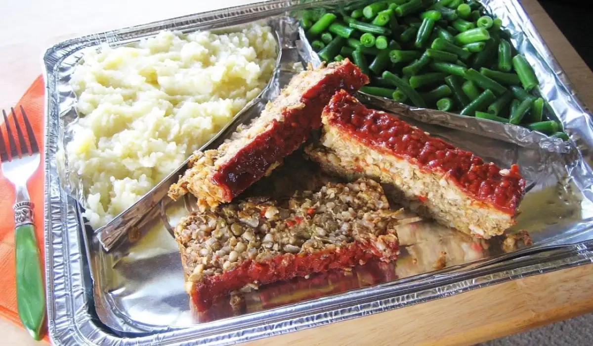 TV dinner of meatloaf and mashed potatoes plated in its own aluminum tray