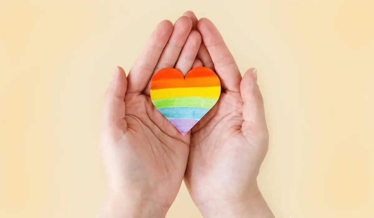 Coming out, heart with rainbow lgbt flag in hands