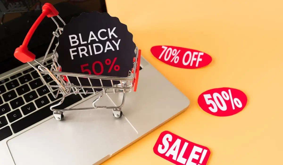 Shopping cart on top of laptop with black friday discount stickers
