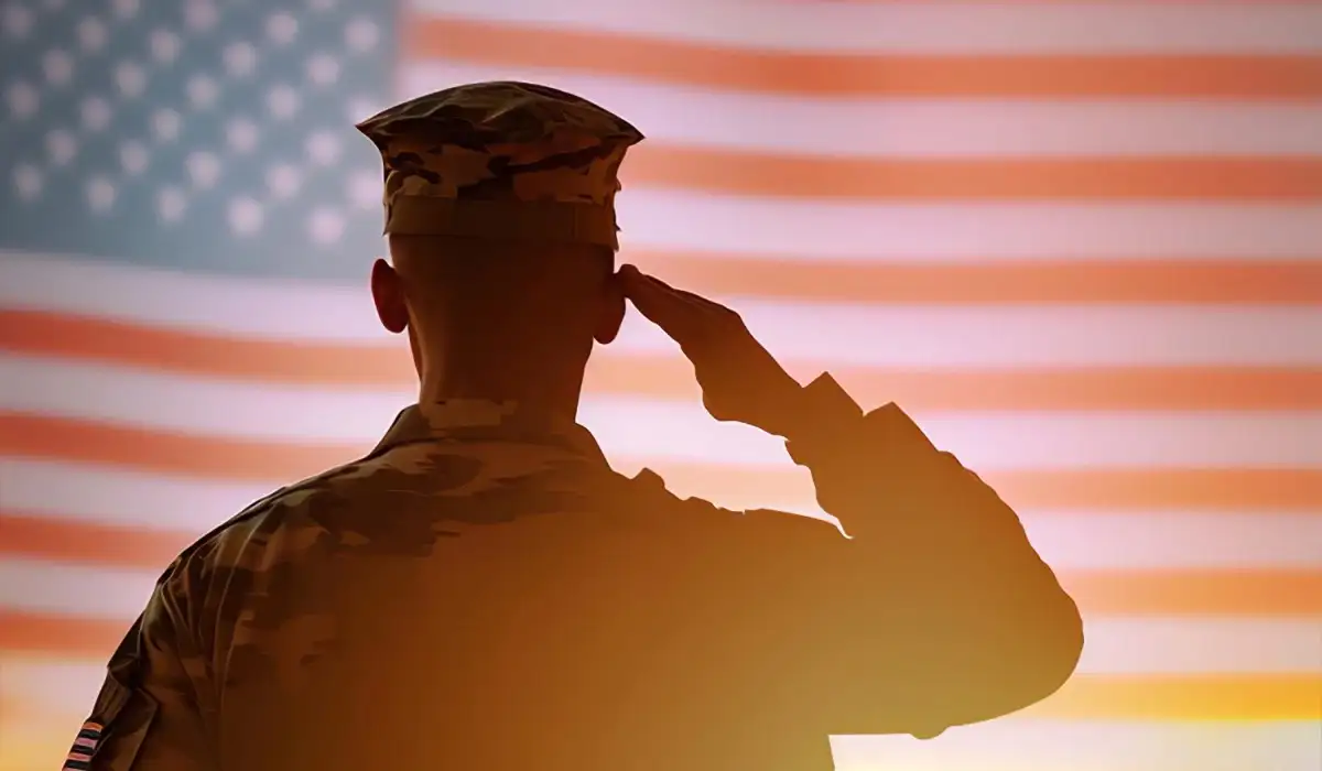 Soldier and American flag in the background at sunrise