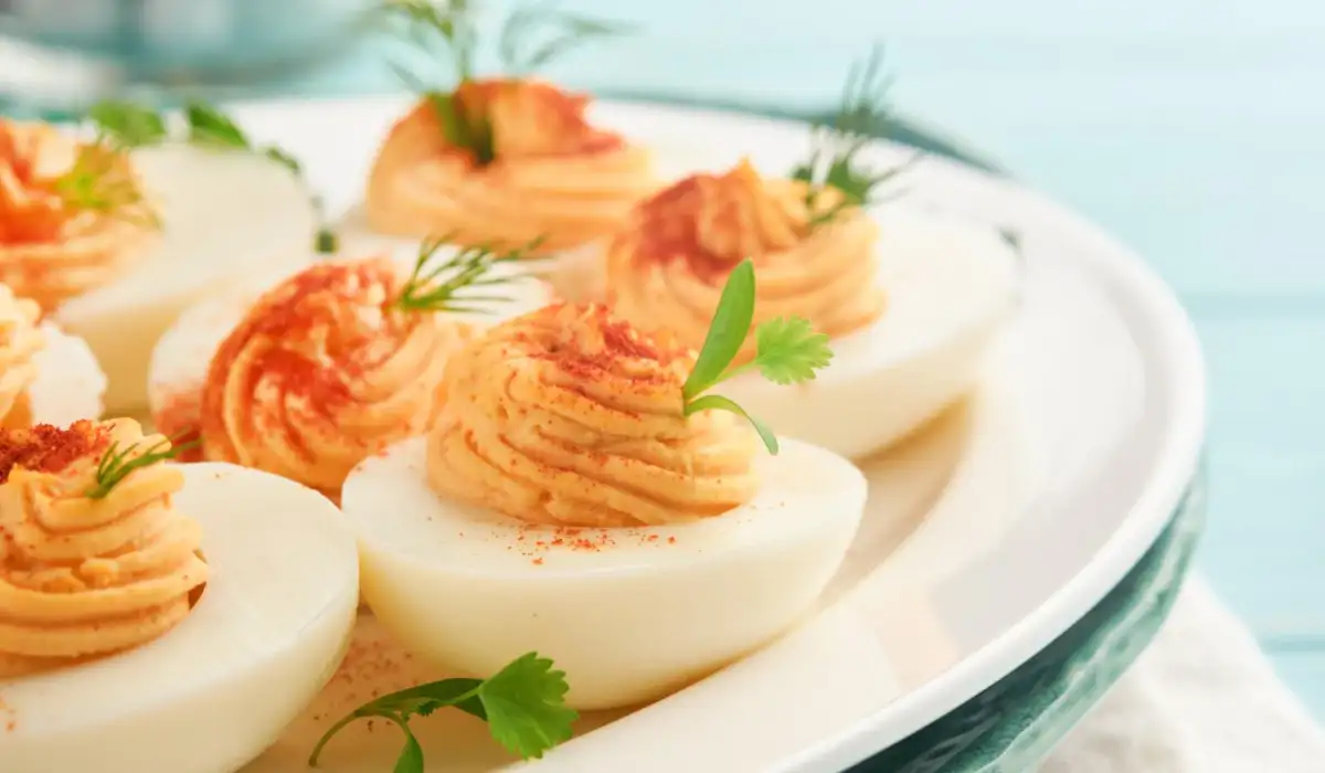 Stuffed eggs with paprika and parsley on a blue plate for the table