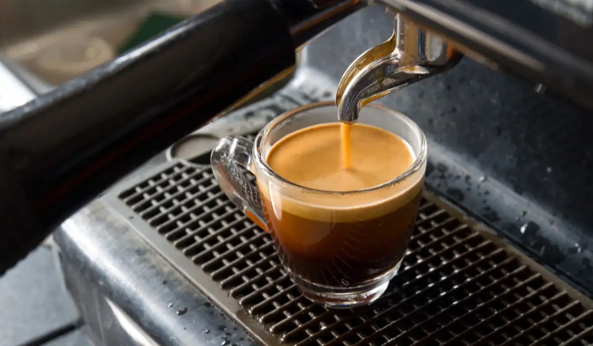 A coffee maker making espresso in a glass cup