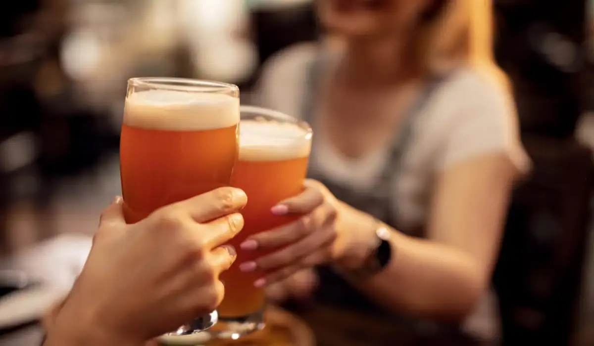 Close up of an unrecognizable couple toasting with beer in a bar