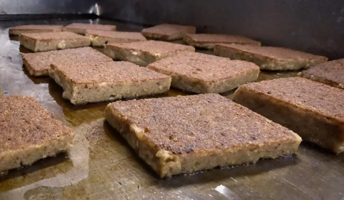 Several pieces of scrapple on a wooden surface