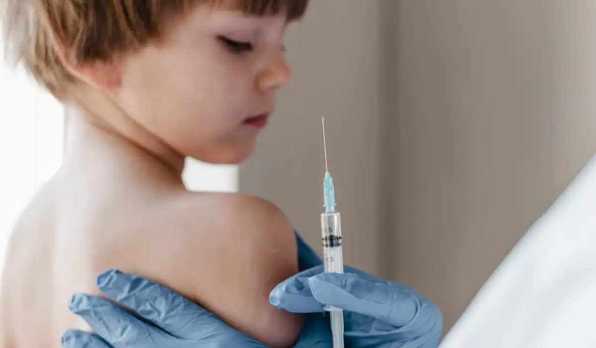 Doctor with gloves performing a vaccination on little boy