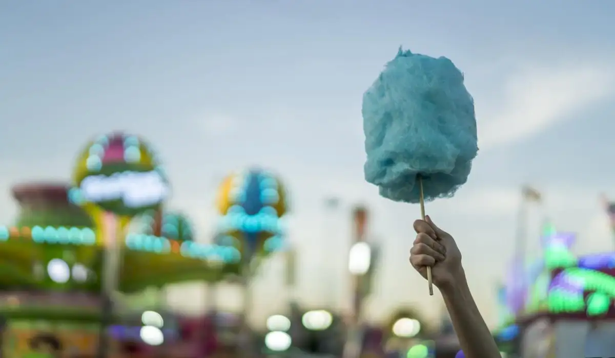 Woman holding blue cotton candy at amusement park