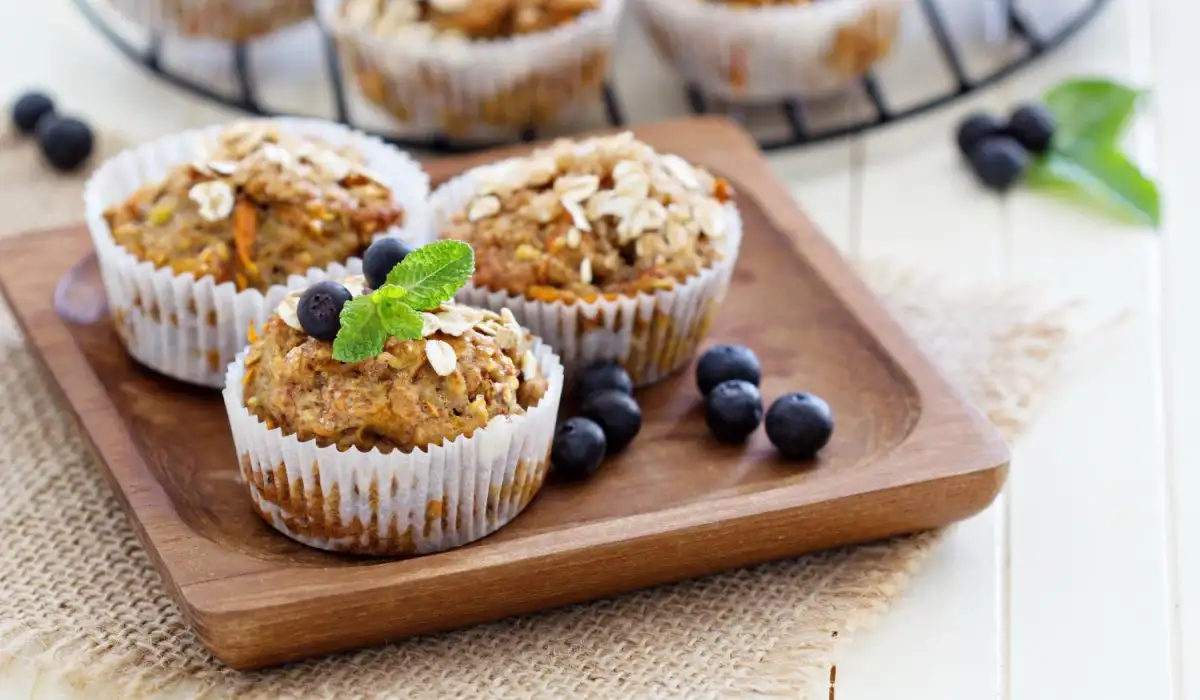 Oatmeal muffins with blueberries with some mint leaves, all on a wooden board